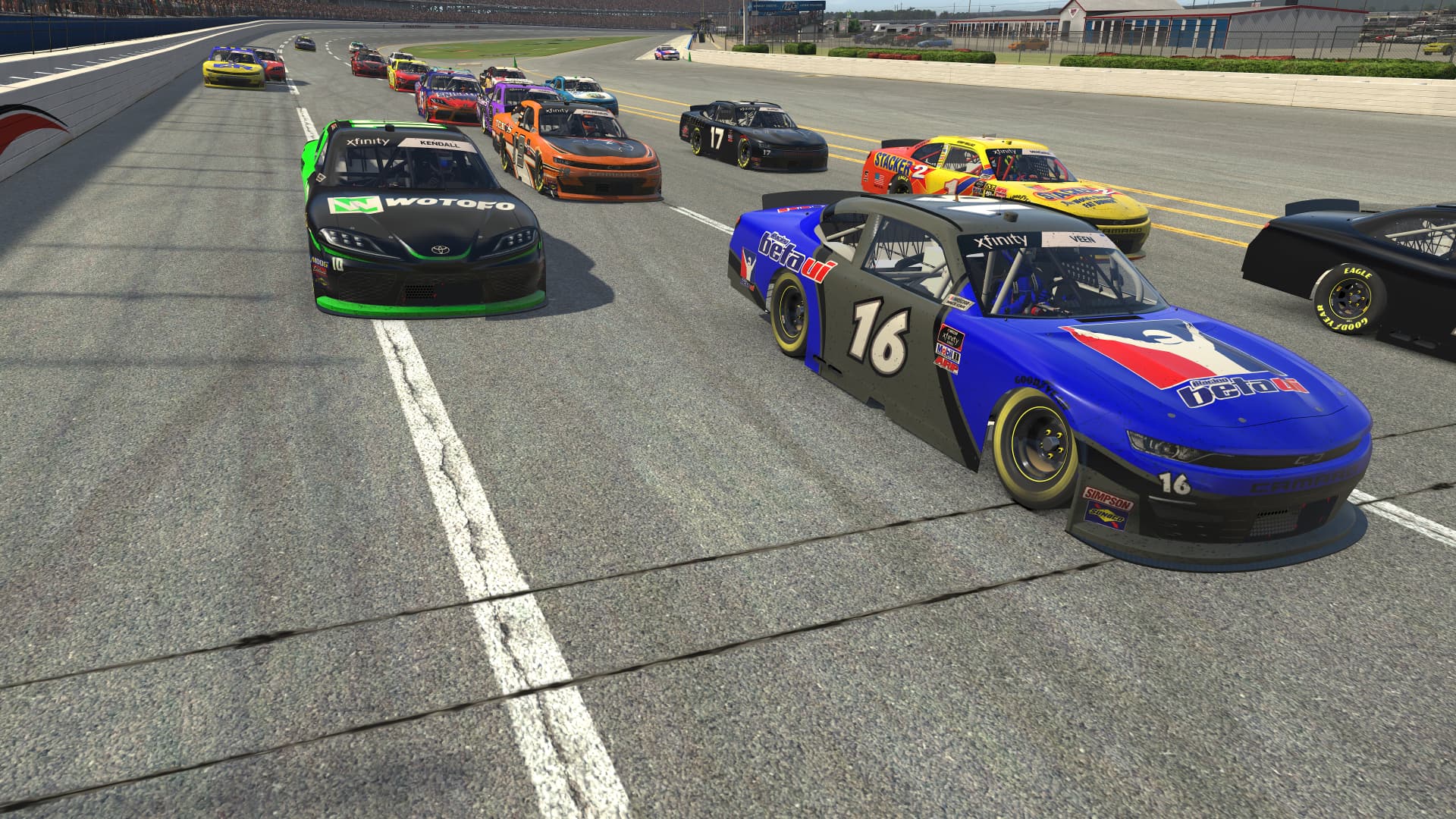 A pack of stock cars running three-wide down the front stretch at Talladega Superspeedway in iRacing.